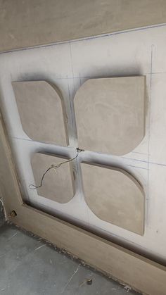 an unfinished wall with four pieces of cut out paper