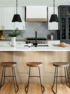 three stools sit at the center of a kitchen island