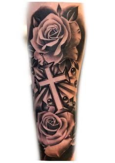 a black and white tattoo with roses on the arm, cross and arrows in the middle