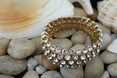 This is the perfect option for those who like cool, unique jewelry and the luxury, shine of gold, clear. This bracelet is well made, cute and/or elegant in design, and very desirable. ❤️ The bracelet is decorated with CZ. ❤️ The bracelet is dimensionless (stretching) ♥ Age/Era: Circa before the 2000s. ♥ There is no hallmark. ♥ The bracelet is about 1 inch wide. ♥ Some stones are lost. Everyone interested in the jewelry should remember that he or she must like their jewelry- not just at first sig Gold Rhinestone Bracelets As Gift, Gold Crystal Bracelets With Jewels, Gold Rhinestone Bracelets For Gifts, Gold Bracelets With Rhinestones For Gifts, Adjustable Dazzling Gold Bracelet, Gold Bracelets With Sparkling Stones, Glamorous Gold Metal Crystal Bracelet, Gold Metal Crystal Bracelet With Bling, Gold Crystal Bracelet With Jewels