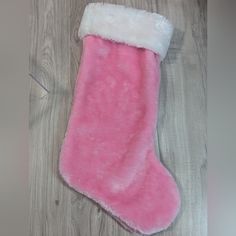 a pink and white stocking laying on top of a wooden floor