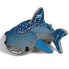 a blue and white fish sculpture sitting on top of a pile of paper napkins