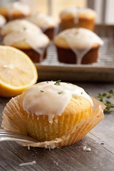 lemon muffins with icing sitting on a wooden table