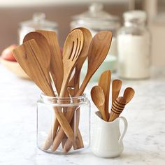 wooden utensils in a glass jar on a counter