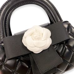 This quilted purse has an eloquent floral applique over a black bow and magnetic clasp. 100% PU leather. Comes with detachable gold chain. Dimension:- 6-3/4" Length x 7" height (included handle)/ 4-1/4" height (excluded handle) x 1-3/4" Width Chic Evening Shoulder Bag With Flower Shape, Elegant Quilted Party Bag, Glamorous Gold Bag With Detachable Handle, Black Bag With Detachable Round Handle, Elegant Black Heart-shaped Bag, Chic Flower-shaped Evening Shoulder Bag, Luxury Elegant Flower-shaped Bags, Elegant Heart-shaped Bag With Zipper Closure, Quilted Purse