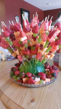 a platter filled with fruit on top of a wooden table