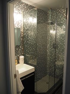 a walk in shower sitting next to a white sink