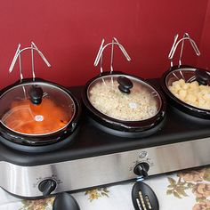 three pots with food in them sitting on top of a counter next to an air fryer