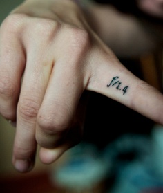 a person with a small tattoo on their finger pointing to the left and right hand