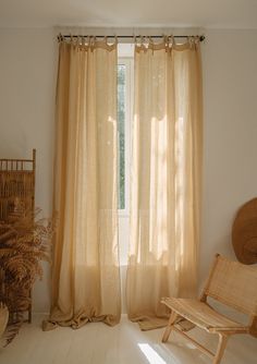 a chair sitting in front of a window next to a potted plant