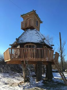 a tree house built into the side of a snow covered hill