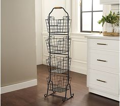 a tall metal rack with baskets on it in a room next to a white wall