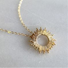 "This beautiful sun pendant necklace will be your favorite dainty jewelry!  Wear this as a reminder to always shine bright. Classic and elegant, it's perfect for everyday or as a meaningful gift.   D E T A I L S *15mm sun pendant. *14kt gold filled dainty link chain.  LENGTH *Please select from the drop down selection. *The standard length is normally 18\". *Model is wearing 18\" in Photos. HOW TO PERSONALIZE *Select your choices from the drop down menu to create your custom design. ∙ EXTRA LOVE Elegant Starburst Necklaces For Gifts, Gold Starburst Necklace For Gift, Gold Starburst Jewelry For Gifts, Elegant Sunburst Jewelry Gift, Dainty Gold Starburst Necklace, Starburst Jewelry With Sun Design As A Gift, Sun Design Charm Necklace Gift, Gold Sun Design Jewelry As A Gift, Starburst Sun Design Jewelry Gift