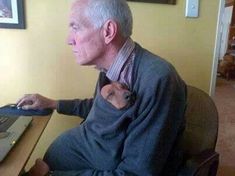 an old man sitting in front of a laptop computer with his arm wrapped around him