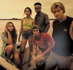 a group of young people sitting on top of a boat