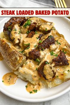 steak loaded baked potato with gravy on white plate next to fork and napkin