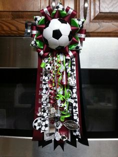 a soccer trophy hanging from the side of a microwave