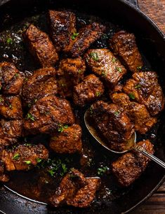 a skillet filled with meat and garnished with parsley