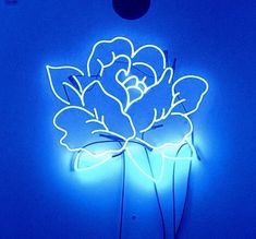 a blue neon sign with a flower on it's side in front of a light bulb