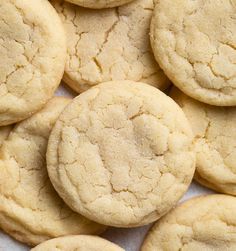 a pile of cookies sitting on top of a white tablecloth next to each other