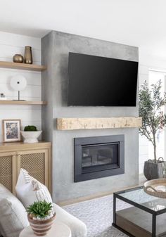 a flat screen tv mounted on the wall above a fireplace in a modern living room