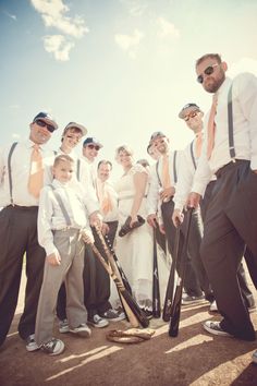 a group of people standing next to each other holding baseball bats