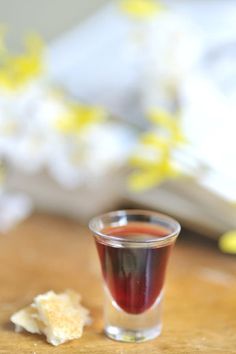 a shot glass filled with liquid sitting on top of a wooden table