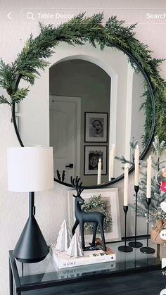 a mirror sitting on top of a dresser next to a table with candles and decorations