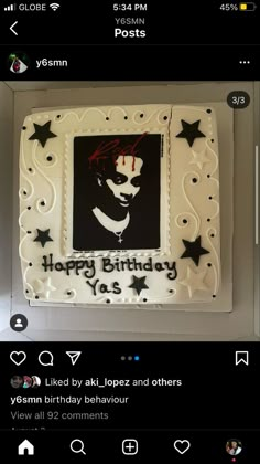 a white birthday cake with black stars and a marilyn monroe photo on the side, in a box