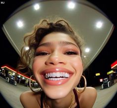 a smiling woman with big hoop earrings and large gold hoop earrings on her head is looking at the camera