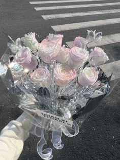 a bouquet of pink roses is wrapped in clear cellophane and tied to a pole