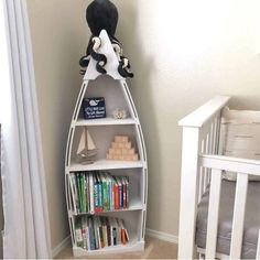 a baby's room with a book shelf and crib in the corner that has books on it