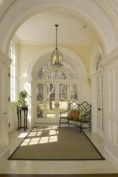 an archway leading to a sitting area with two chairs and a rug on the floor