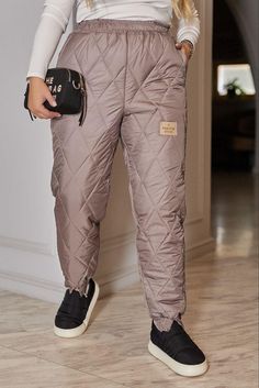 These stylish insulated quilted trousers are a real find for those who value comfort and fashion trends in the cold season. The model is made in a universal black color, which is easy to combine with any wardrobe items, creating both casual and more elegant looks. The quilted design gives the trousers volume and structure, while maintaining warmth and providing comfort in any weather. The trousers are equipped with a comfortable elastic waistband that perfectly adjusts to the figure, providing a comfortable fit. The loose cut and insulated lining guarantee maximum freedom of movement and protection from the cold. The appearance of the product is completed by a stylish patch, giving a unique and modern accent. These trousers will become an indispensable wardrobe item for both city walks and Quilted Trousers, Quilted Pants, Winter Quilts, Winter Pants, Outdoor Fashion, Cold Season, Women's Pants, Trousers Women, Down Jacket