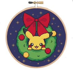 a cross stitch pattern with a pikachu holding a christmas ornament on it