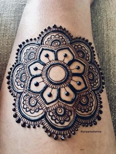 a woman's leg with a tattoo on it that has an intricate design in the middle