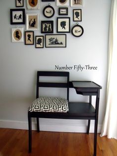 a chair sitting in front of a wall with pictures on it