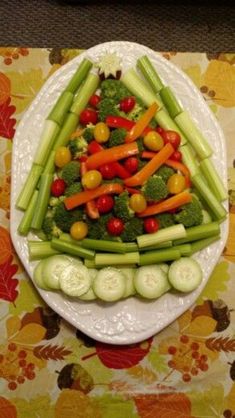 a white plate topped with lots of veggies on top of a floral table cloth