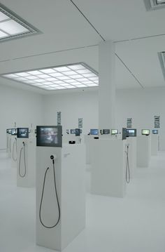 a room filled with white pedestals covered in electronic devices