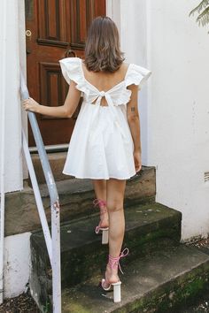 White mini dress Lined Ruffle sleeves Tie feature in back Zipper in back You'll look like an angel in our ethereal Marlina mini dress. We are in love with its babydoll silhouette and super cute ruffle sleeves. Perfect for a bridal shower or graduation. Team it with white, tie up heels and a purse for a look that's straight from Heaven. MODEL INFO Model is wearing size XS Height: 5'5" Bust: 32" Waist: 25" Hips: 33.6" SIZE INFO Flat garment measurements This was manually measured from the actual g Cute Mini Dress With Tie Back, Cute Mini Length Ruffle Dress, White Mini Dress With Ruffled Straps, Cute Style, Cute Mini Dress With Ruffle Sleeves, Cute Flutter Sleeve Mini Dress For Spring, Flowy Sundress With Flutter Sleeves, White Mini Dress With Ruffle Hem And Sleeve, Cute Mini Dress With Ruffled Straps For Day Out, Flowy Mini Dress With Flutter Sleeves For Day Out