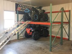 four wheelers are stacked on top of each other in a storage room with ladders