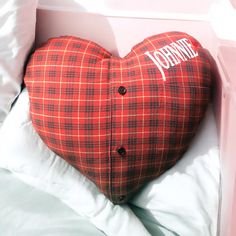 a heart shaped pillow sitting on top of a bed