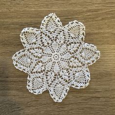 a white doily on top of a wooden table