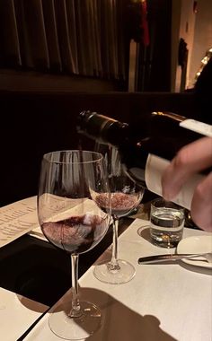 two wine glasses sitting on top of a table