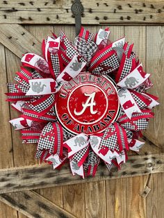 a red and white wreath with the letter a on it that is attached to a wooden door