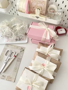 there are many boxes with bows on them and some scissors in the box next to it