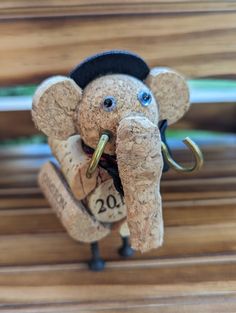 an elephant figurine with a hat and coat on it's head is holding a fishing hook