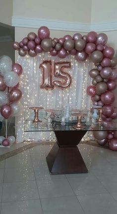 a large balloon arch with the number fifteen on it in front of a dining room table