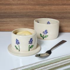 two cups with spoons on a table