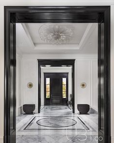 an elegant entry way with marble floors and black framed doors